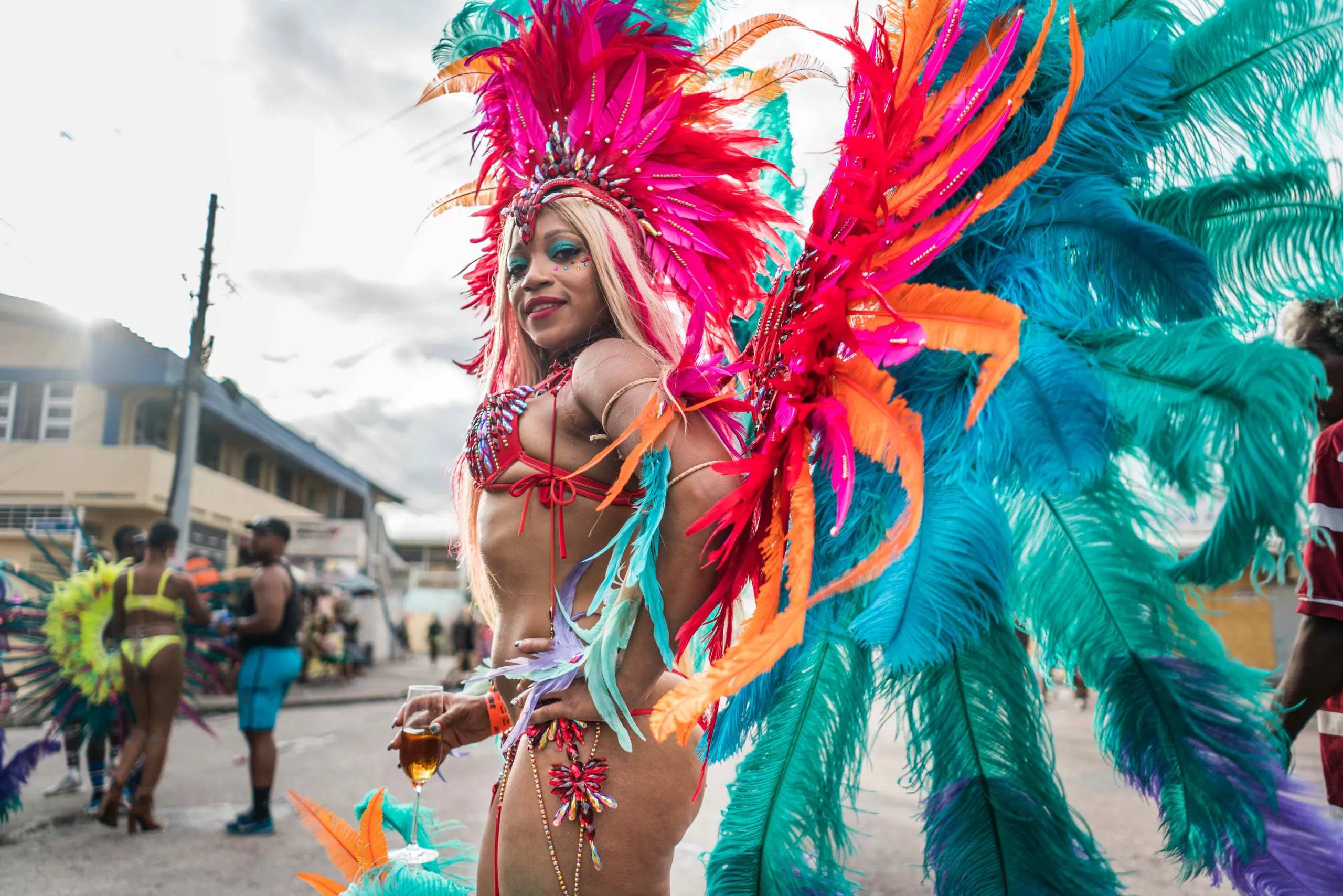A masquerader in orange and turquoise feathers