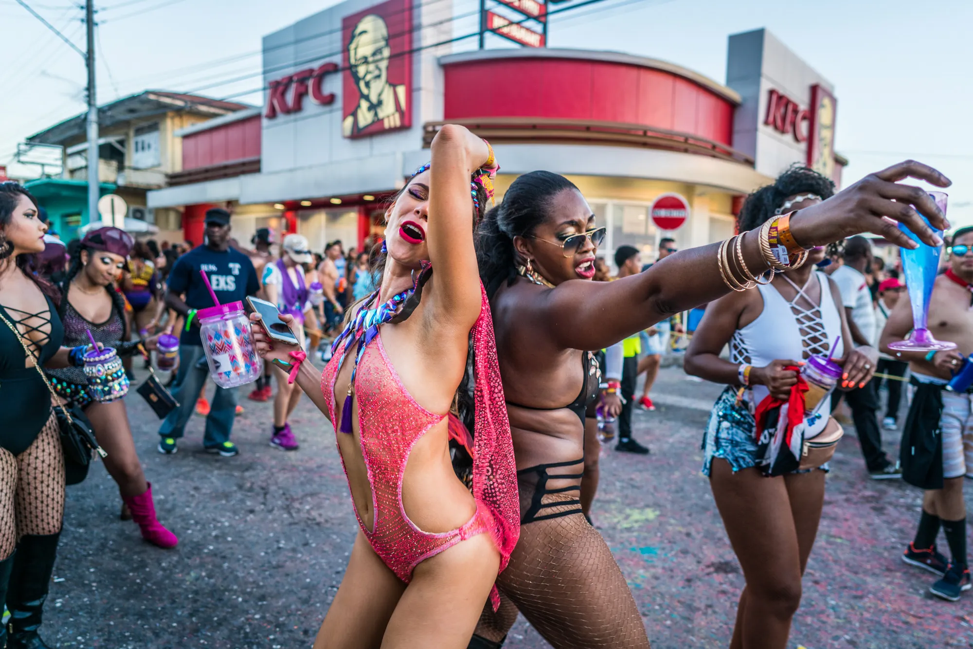 Women dancing in the street outside a KFC