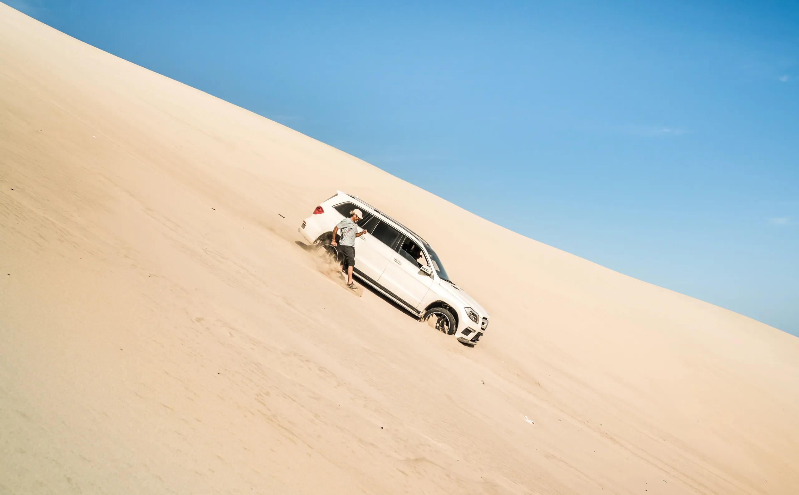 A car parked on the slope of a dune
